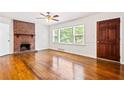 Spacious living room with hardwood floors, a brick fireplace, and ample natural light at 3211 Hollydale Drive Sw, Atlanta, GA 30311
