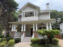 Charming two-story home featuring a welcoming front porch with brick and white pillars and mature landscaping at 2552 White Oak Dr, Decatur, GA 30032