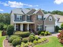 Attractive two-story house showcasing stone accents, well-maintained landscaping, and a cozy front porch at 4665 Idlewood Dr, Cumming, GA 30040