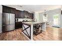 Modern kitchen featuring stainless steel appliances, a large island, granite countertops, and dark wood cabinets at 319 Nobleman Way, Canton, GA 30114