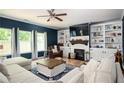 Cozy living room with built-in bookshelves, a fireplace, recessed lighting, and large windows at 319 Nobleman Way, Canton, GA 30114