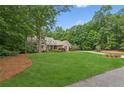 Inviting home with sprawling lawn, mature trees, and a curved driveway entrance at 3445 Strawberry Ln, Cumming, GA 30041