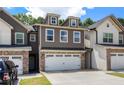 Inviting townhome displaying a two-car garage and charming curb appeal with well-maintained landscaping at 7805 Rock Rose Ln, Fairburn, GA 30213