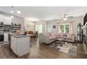 Open-concept living space with hardwood floors, kitchen island, dining, and cozy seating area at 7805 Rock Rose Ln, Fairburn, GA 30213