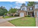 View of townhomes with landscaped front yards and attached garages at 3461 Dianthus Ln, Lawrenceville, GA 30044