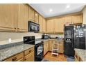 Features wooden cabinets, granite countertops and black appliances at 3461 Dianthus Ln, Lawrenceville, GA 30044