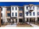 New townhomes featuring modern design, brick accents, and landscaped front yards with wrought iron fencing at 354 Olmstead Way # 27, Alpharetta, GA 30022