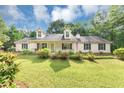 Inviting single-Gathering home with a well-maintained lawn, mature trees, and a welcoming front porch at 1050 Birdseye Vw, Locust Grove, GA 30248