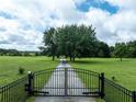 Gated entrance leads to a private estate with expansive green lawn and mature trees at 1502 Campground Rd, Mcdonough, GA 30252