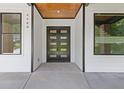 Inviting front entrance with a modern black double door and white siding at 2060 North Avenue Nw, Atlanta, GA 30318