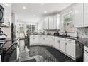 Spacious kitchen featuring white cabinets, black countertops, and stainless steel appliances at 3223 Thornecreek Dr, Douglasville, GA 30135