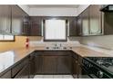 Functional kitchen featuring dark wood cabinets, neutral countertops, and a stainless steel sink at 460 E Kildare Nw Ave, Atlanta, GA 30318