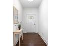 Bright entryway features hardwood floors, a charming table with flowers, and a decorative mirror at 5316 Radford Loop, Fairburn, GA 30213