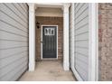 Inviting front entrance with gray siding, brick accents, and a stylish black door with glass panel at 5316 Radford Loop, Fairburn, GA 30213