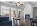 Open-concept living room with hardwood floors, a fireplace, and abundant natural light at 5316 Radford Loop, Fairburn, GA 30213