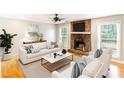 Bright living room features a stone fireplace, hardwood floors, and neutral decor at 674 Crespan Ct, Lawrenceville, GA 30044