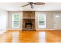 Spacious living room featuring a stone fireplace and hardwood flooring at 674 Crespan Ct, Lawrenceville, GA 30044
