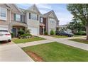 Attractive townhome with a single-car garage, complemented by a lush green lawn and driveway at 359 Azalea Cir, Cumming, GA 30028