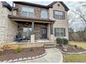 Charming front porch area with a cozy seating area and beautiful landscaping at 719 Lilac Mist Dr, Loganville, GA 30052