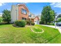 Well-manicured front yard with lush green grass, mature trees, and tidy landscaping surrounding a brick home at 1777 Cutters Mill Way, Lithonia, GA 30058