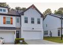 Charming two-story townhouse with white brick, a two-car garage, and contemporary design elements at 375 Auburn Valley Way, Auburn, GA 30011