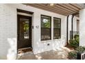 Exterior of white brick townhouse featuring front door with glass panes, and manicured landscaping at 92 Rogers Ne St, Atlanta, GA 30317