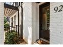 Exterior of white brick townhouse featuring black front door with glass panes, and manicured landscaping at 92 Rogers Ne St, Atlanta, GA 30317
