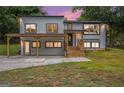 Charming renovated two-story home at dusk, featuring new windows, modern finishes, and a welcoming covered porch area at 3831 Flakes Mill Rd, Decatur, GA 30034