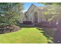 Beautifully landscaped front yard of an elegant brick home, showcasing lush green lawn and mature trees at 8430 Merion Drive, Duluth, GA 30097