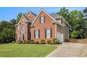 Lovely brick home, showcasing an attached garage and a neatly maintained lawn with landscaping at 1006 Kingsbridge Vw, Powder Springs, GA 30127