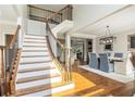 Bright foyer with hardwood floors, elegant staircase, and open access to dining area at 1006 Kingsbridge Vw, Powder Springs, GA 30127