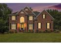 Charming two-story brick home featuring a well-manicured lawn and a symmetrical design during sunset at 1006 Kingsbridge Vw, Powder Springs, GA 30127