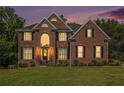 Beautiful two-story brick home with manicured lawn, illuminated by soft, inviting light at 1006 Kingsbridge Vw, Powder Springs, GA 30127