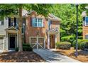 Two-story townhouse featuring a brick facade, attached garage, and neatly landscaped front yard at 1414 Dolcetto Nw Trce # 14, Kennesaw, GA 30152