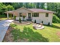 Charming home showcasing a stone facade, landscaped front yard, and brick steps leading to the entrance at 1641 Rockcliff Se Pl, Atlanta, GA 30316