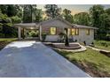 Charming home featuring a covered carport, stone accents, landscaped yard, and concrete driveway at 1641 Rockcliff Se Pl, Atlanta, GA 30316