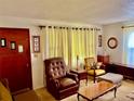 Cozy living room featuring a recliner, yellow chair, and natural light from curtain-covered windows at 1968 Don Juan Ln, Decatur, GA 30032