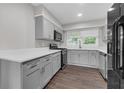 Updated kitchen with stainless steel appliances, gray cabinets, white counters, and hardwood floors at 2683 Rockcliff Se Rd, Atlanta, GA 30316