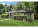Lovely single-story home with lush landscaping and manicured lawn, blending privacy and curb appeal at 3093 Del Monico Dr, Decatur, GA 30032