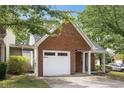 Exterior view of a brick home with an attached one-car garage and an inviting, covered entrance at 3063 Broadleaf Trl, Fairburn, GA 30213