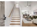 Bright living room with a staircase, open to a kitchen with bar seating and a comfortable living space at 3063 Broadleaf Trl, Fairburn, GA 30213