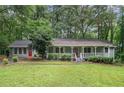 Charming single-story home with a welcoming front porch and a lush green lawn surrounded by mature trees at 5317 Highway 81, Loganville, GA 30052