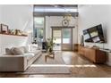 Sunny living room featuring high ceilings, a modern couch, and large windows at 1661 La France Ne St # 222, Atlanta, GA 30307