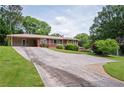 Long driveway leading to a single-story brick home with carport and mature landscaping at 3332 Clay Rd, Austell, GA 30106
