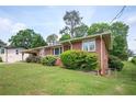This charming single-story brick home features mature landscaping and an expansive, well-maintained lawn at 3332 Clay Rd, Austell, GA 30106