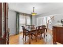 Dining area with hardwood floors, a chandelier, and natural light streaming in through curtained windows at 7335 Treyland Ct, Cumming, GA 30041