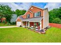 A two-story brick home exhibits a pristine lawn and lush greenery at 5388 Silver Springs Dr, Sugar Hill, GA 30518