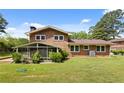 Spacious backyard featuring a screened-in porch, green lawn, and mature landscaping at 3082 Briarleaf Dr, Decatur, GA 30034