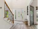 Bright entryway with a staircase featuring black metal accents and light gray vinyl flooring at 1667 Willow Way, Woodstock, GA 30188