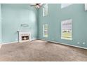 Spacious living room featuring a fireplace, large windows, and a ceiling fan at 750 Ambrose Ln, Atlanta, GA 30349